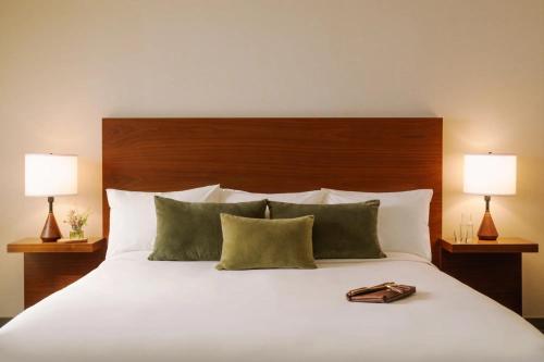 a bed with two lamps and a purse on it at FOUND Hotel, Santa Monica in Los Angeles