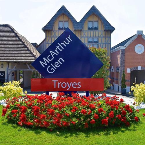 a sign in front of a building with red flowers at Au Jardin d'Olga in Mesnil-Saint-Père