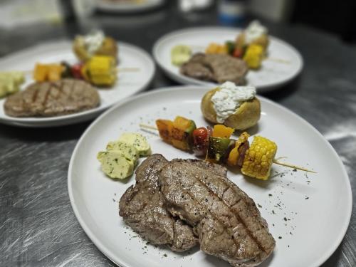 a plate of steak and vegetables on a table at Windhoek Game Camp in Lafrenz Township