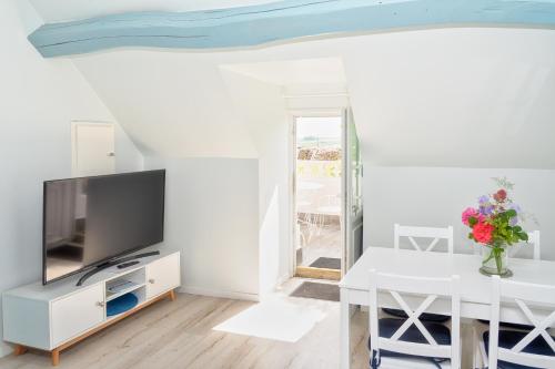 uma sala de estar com uma televisão e uma mesa em Gîte de charme, grand confort em Marolles-sous-Lignières