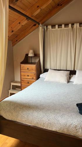 a bedroom with a large bed and a wooden dresser at Terrazas del Pirineo en Villanúa in Villanúa