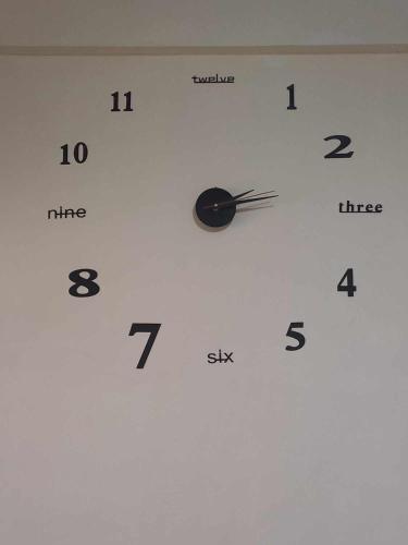 a white clock with black numbers on a wall at Condo for Rent - Cagayan de Oro in Cagayan de Oro