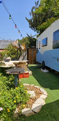 una mesa de picnic en un patio junto a una caravana en Countryside, beach view glamping caravan en HaBonim