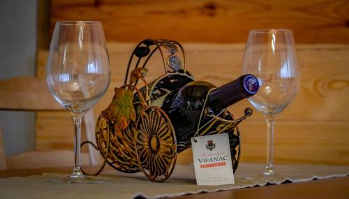 - deux verres à vin et une bouteille de vin sur une table dans l'établissement Family Farm Pejovic, à Žabljak