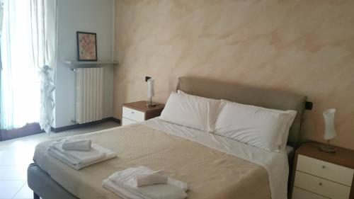 a bedroom with a bed with two towels on it at Caba Holiday Bardolino Pasubio in Bardolino