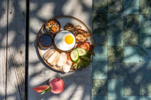 een bord eten met een ei op een tafel bij MASMARA Resort Canggu in Canggu