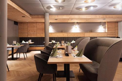 une salle à manger avec des tables, des chaises et une table dans l'établissement Ferienwelt Kesselgrub Hotel in Altenmarkt-Zauchensee, à Altenmarkt im Pongau