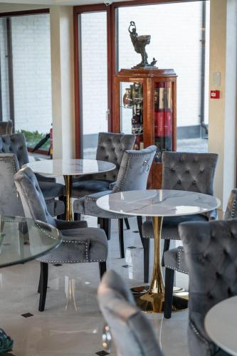 a group of tables and chairs in a room at Amber VIP Hotel in Pāvilosta