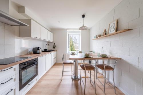 une cuisine avec une table et des chaises dans l'établissement Duplex 5 chambres à la frontière luxembourgeoise, à Volmerange-les-Mines