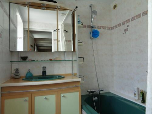 une salle de bain avec un lavabo, une baignoire et un miroir dans l'établissement T3 de charme meublé, 70 m2,centre ville Douarnenez, à Douarnenez