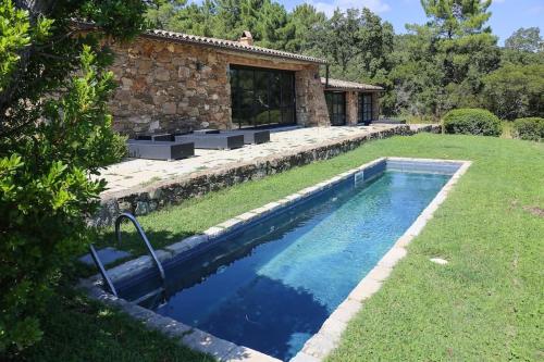 une piscine dans une cour à côté d'une maison dans l'établissement Bergerie dans les Vignes, à Bormes-les-Mimosas