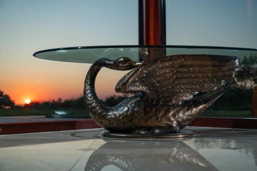 a bronze bird statue sitting on a glass table at Amber VIP Hotel in Pāvilosta