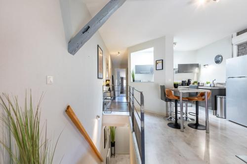 une cuisine et un salon avec des murs blancs dans l'établissement Le Canopé - Duplex Confort, Hypercentre, 2 Salles d'eau, à Castres