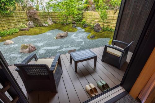 a patio with chairs and a garden with rocks at 箱根仙石原の宿 よいな in Hakone