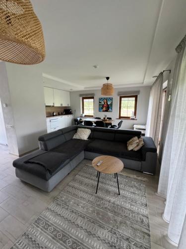 a living room with a black couch and a table at Seaside home Pape in Pape
