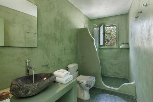 a green bathroom with a sink and a toilet at Zatrikion Santorini Villas in Pirgos