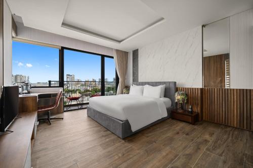 a hotel room with a bed and a balcony at Tashi Oasis Hotel & Apartment Da Nang in Da Nang