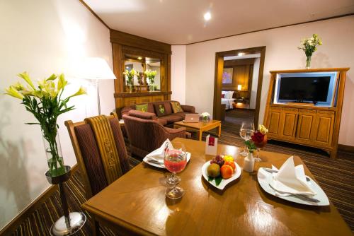 a living room with a wooden table with fruit on it at Sima Thani Hotel in Nakhon Ratchasima