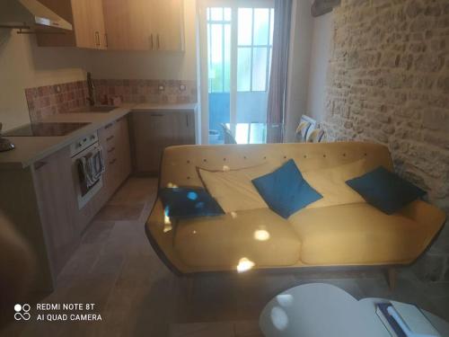 - un canapé dans une cuisine avec des oreillers bleus dans l'établissement Charmant Appartement 2 pièces avec extérieur, à Dijon