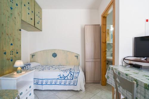 een slaapkamer met een bed, een ladekast en een televisie bij Monolocale San Giovanni Posada in San Giovanni