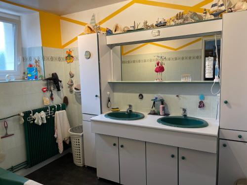 un bagno con due lavandini e uno specchio di Au repos du Lezard , l italienne a Durtal