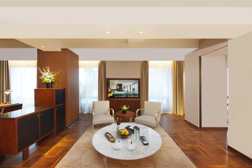 a living room with a table and chairs in a room at Maxx by Steigenberger on the Bund Shanghai in Shanghai