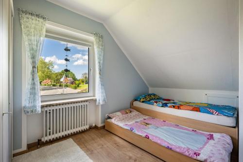 2 camas individuais num quarto com uma janela em Ferienhaus Ostseetraum em Göhl