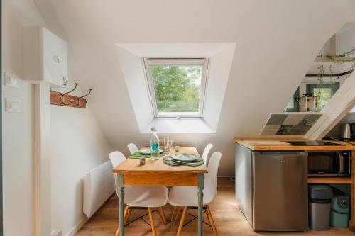 a small kitchen with a wooden table and chairs at Gite Nichoir 2ad et 2 enf in Plurien