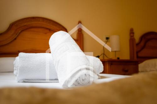 a pile of towels sitting on a bed at El gayo - Apartamento en Luanco in Luanco