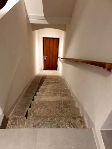 a stairway with a wooden door in a building at A central quiet sunny studio in Verbania in Verbania