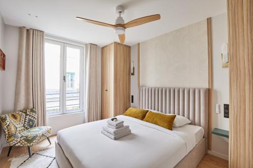 une chambre avec un lit blanc et une chaise dans l'établissement Apartment center of Paris by Studioprestige, à Paris