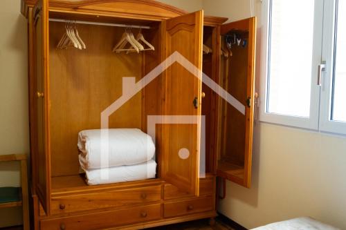 a wooden hutch with towels in it in a room at El gayo - Apartamento en Luanco in Luanco