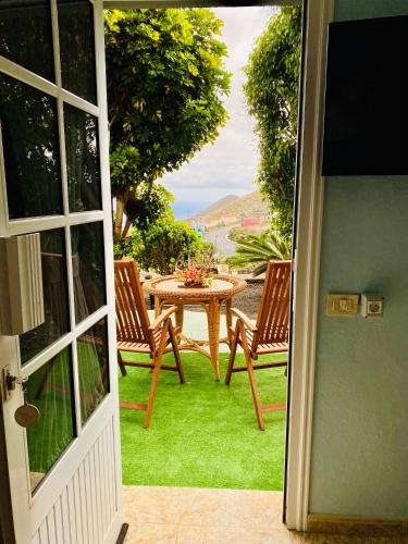 a door open to a patio with a table and chairs at Casa El Potrero in Mocanal