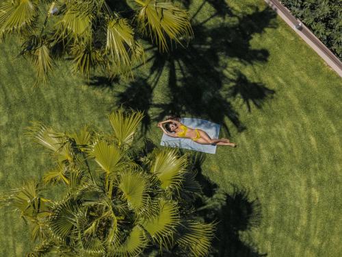 Un hombre tumbado en el césped junto a unas palmeras. en Margarites villas, en Margarítai