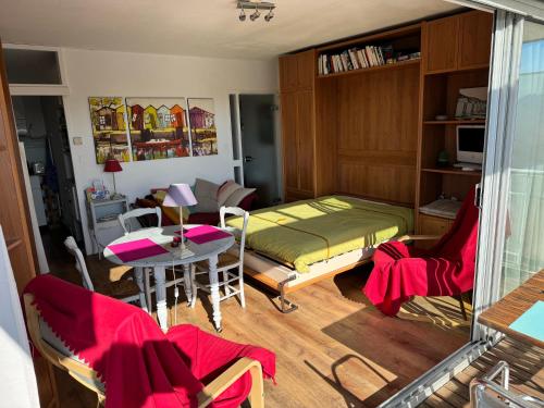 een slaapkamer met een bed en een tafel en stoelen bij Studio joigny Pereire in Arcachon