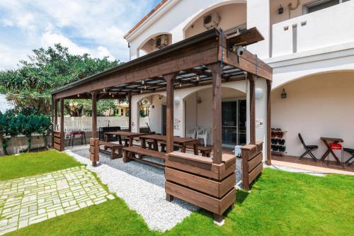 a wooden pavilion in the backyard of a house at ペンション アネラニハウス沖縄 in Onna