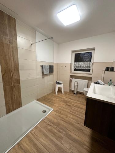 een badkamer met een wastafel en een bad bij Ferienwohnung Korneli in Grenderich