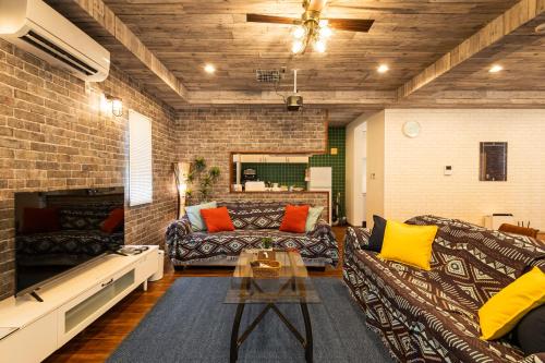 a living room with a couch and a table at ペンション アネラニハウス沖縄 in Onna