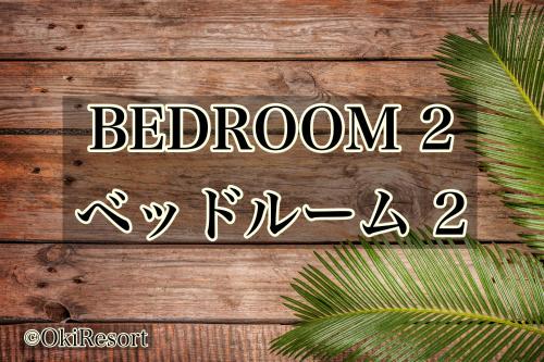 a sign that says bedroom and pizza on a wooden wall at ペンション アネラニハウス沖縄 in Onna
