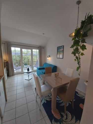 un salon avec une table et un canapé bleu dans l'établissement Superbe vue sur le golf, à Talmont-Saint-Hilaire