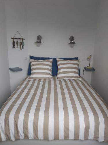 - un lit avec deux oreillers à rayures dans une chambre dans l'établissement Superbe vue sur le golf, à Talmont-Saint-Hilaire