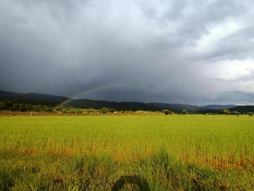 a rainbow in the sky over a field at Alojamiento Rural El Cerro in Fresneda de la Sierra