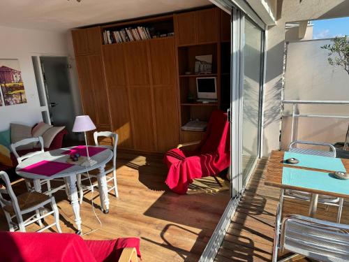 een woonkamer met een tafel en stoelen in een kamer bij Studio joigny Pereire in Arcachon