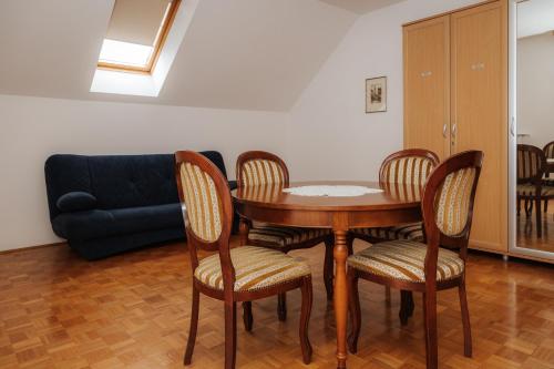 a table and chairs in a living room with a couch at Premium house Anika in Rogaška Slatina