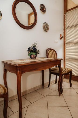 a table with two chairs and a mirror on the wall at Premium house Anika in Rogaška Slatina