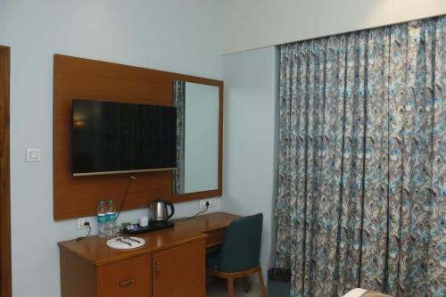 a hotel room with a desk and a mirror at The Hub Link in Mumbai