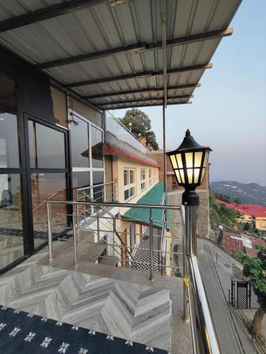 a balcony with a street light and a building at Sangam by Stotrak, Jhula Ghar Mussoorie in Mussoorie