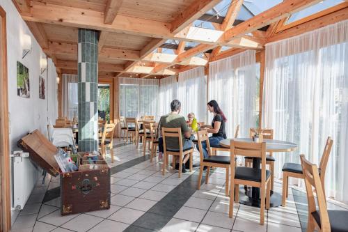 Un uomo e una donna seduti a un tavolo in un ristorante di Bauernhof Pension Hofmayer a Sankt Kanzian