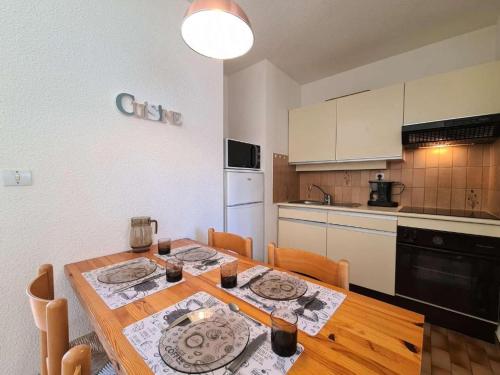 une cuisine avec une table en bois et une salle à manger dans l'établissement La Rouquille Cap d'Agde,, au Cap d'Agde