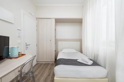 a bedroom with a bed and a desk with a television at Hotel Maggiore in Bologna